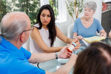 Two women and man with prescription bottle sitting down