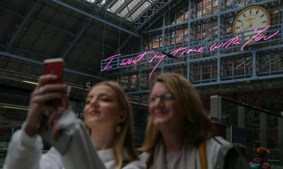 Visitors take a selfie in front of Tracey Emin’s installation at St Pancras International station.