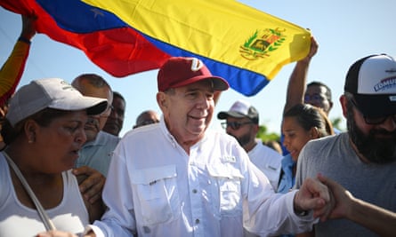 Man in red baseball cap underneath Venezuelan flag