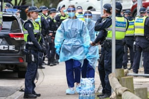 Medical staff wearing PPE holding material about to walk into the Flemington Public housing flats. Nine public housing estates have been placed into mandatory lockdown and two additional suburbs are under stay-at-home orders as authorities work to stop further COVID-19 outbreaks in Melbourne