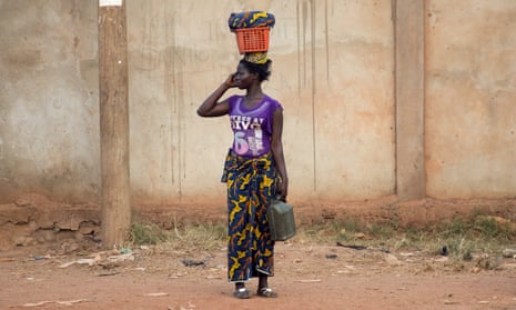 A woman stands by a road in the Central African capital, Bangui, using a mobile phone.