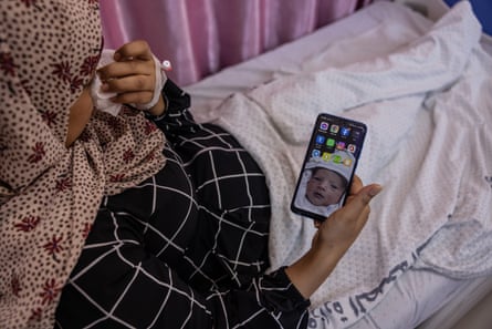Wissam Maher Mater looks at a picture of her second child, who she is unable to see because he is in a different hospital in intensive care