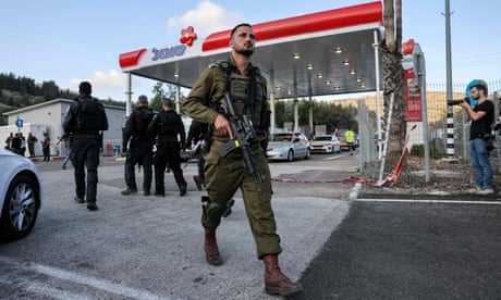 Un soldado israelí sale de una gasolinera en el lugar de un ataque cerca del asentamiento judío de Eli.