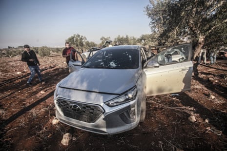 Palestinians inspect a vehicle targeted near Israeli-occupied Jenin by Israeli forces.