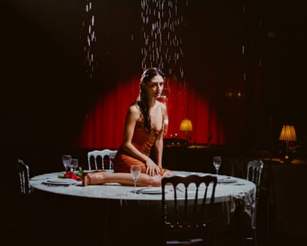 In a still from the video for Actress, Sofie Royer sits on a dining table as it rains from above