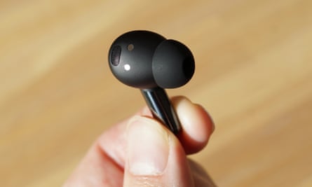 A OnePlus Buds Pro 2 earbud held up by fingers.