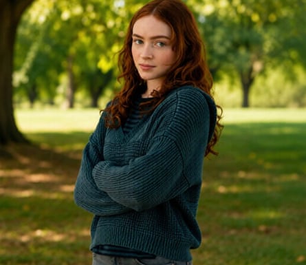 person wearing dark turquoise sweater crosses arms while standing outside