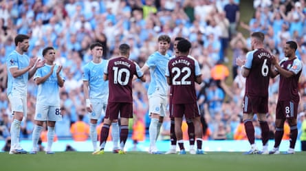 John Stones walks through a guard of honour formed of Manchester City and Aston Villa players