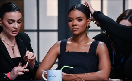 woman wearing black top looks at camera as other people do her hair and makeup woman wearing black top looks at camera as other people do her hair and makeup