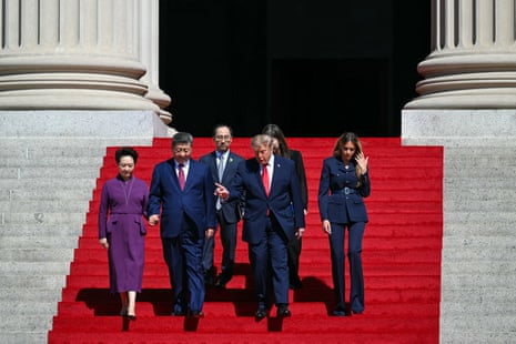 Trump, Xi, and both their wives walking down a carpeted set of marble steps.