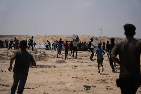 Palestinians collect humanitarian aid packages from the United Arab Emirates after they were airdropped into Deir al-Balah, in central Gaza Strip.
