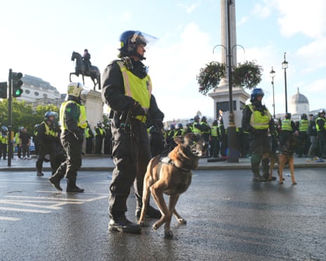 Police officers with dogs patrol around Trafalgar Square in central London.