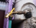 A padlock secures a brass outdoor water tap in Taiz