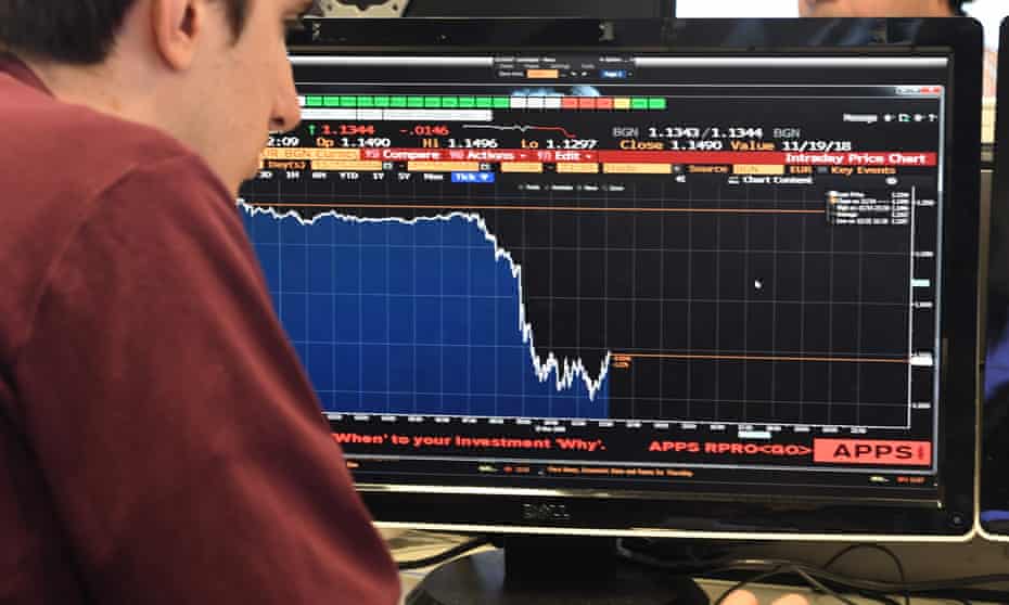 A journalist looks at a Bloomberg terminal showing the drop in the value of the pound.