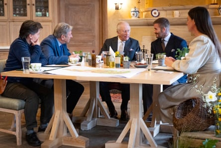 The King sits at a table with his garden advisers