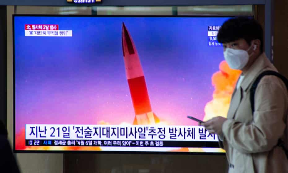 A man in Seoul walks past a TV screen airing a report on North Korea’s latest missile launch
