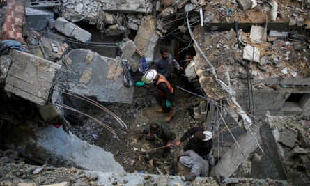People walk among debris after an Israeli strike on a house in Rafah