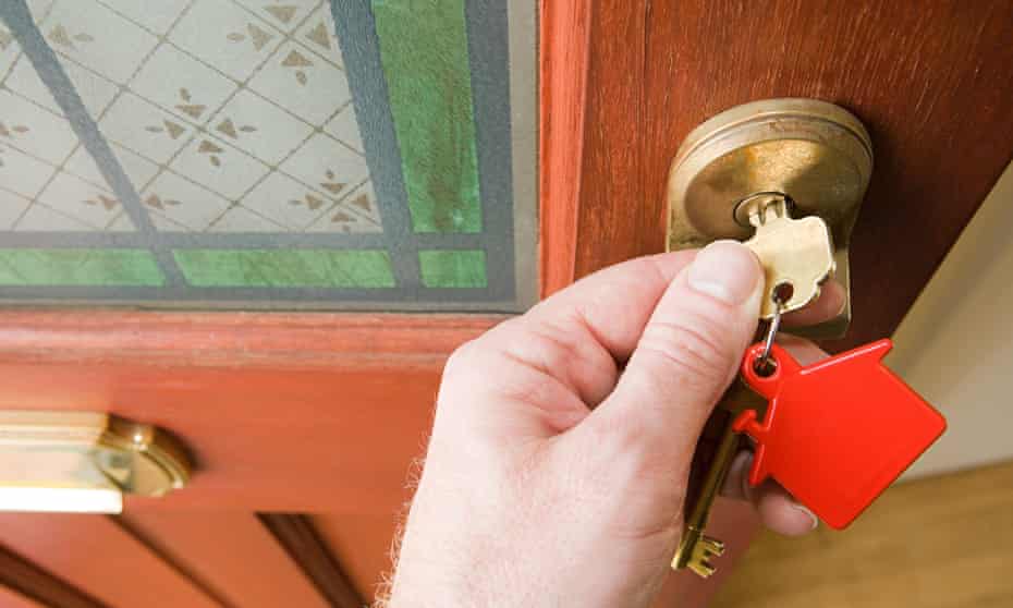 A person opens a door using a key