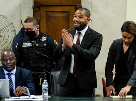 man wearing black suit puts hands together while in court
