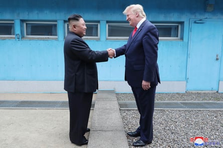 Kim Jong-un dhe Donald Trump shtrëngojnë duart mbi vijën e demarkacionit ushtarak në fshatin kufitar Panmunjom në Zonën e Demilitarizuar Koreane më 30 qershor 2019.