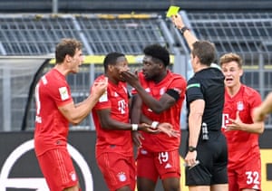 Allphonso Davies of Bayern Munich is shown a yellow card by Referee Tobias Stieler.