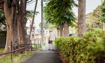 An elderly man walks his dog.