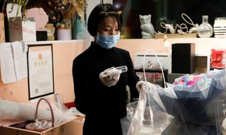 Cai Xiaoman puts a bottle of hand sanitiser into a bouquet.