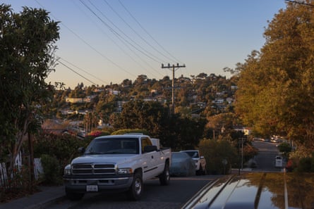 Cars on a tree-lined street in a suburban town.