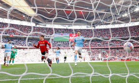 Alejandro Garnacho wheels away in celebration after scoring for Manchester United against Manchester City.