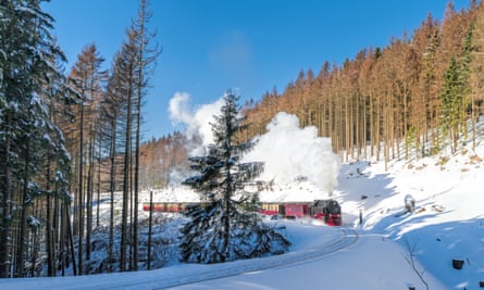 White snow and blue skies: a historical steam train running full speed to Brocken mountain in the Harz region.