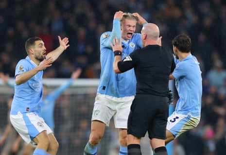 3 December 2023Referee Simon Hooper is surrounded by Erling Haaland, Mateo Kovacic and Rúben Dias of Manchester City after he stopped the game to award Manchester City a free-kick, denying Jack Grealish the chance to score a late goal against Tottenham Hotspur at Etihad Stadium. The game ended 3-3.