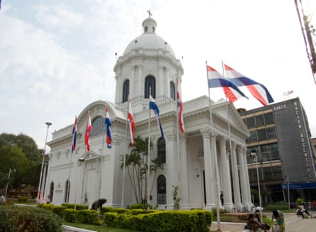 a neoclassical building flanked by flags