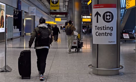 A passenger walks past a sign for the Covid testing centre at London’s Heathrow airport