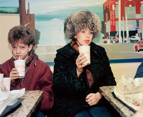 A boy with a woman in a fur hat, holding paper cups with straws in them, in McDonald’s in Moscow in 1992