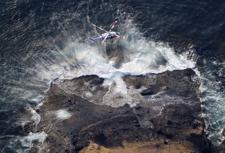 A Japan coast guard helicopter searches for missing people from the missing tour boat Kazu 1 at the Shiretoko Peninsula.