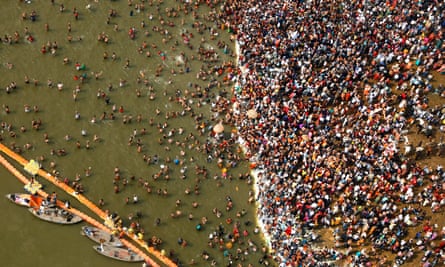 An aerial view of Hindu devotees in the water at the intersection of the Yamuna and Ganges rivers
