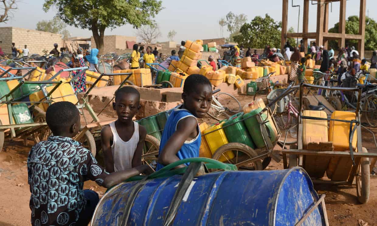Image of children waiting to buy water in Ouagadougou, Burkina Faso, one of the countries most at risk from ecological threats. Photograph: Anne Mimault/Reuters