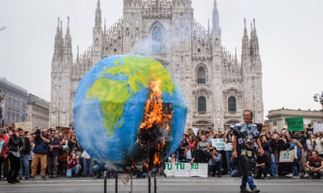 Students set fire to a model of the Earth during a climate change protest in Milan