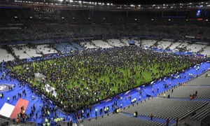 Spectators gather on the pitch of the Stade de France stadium.