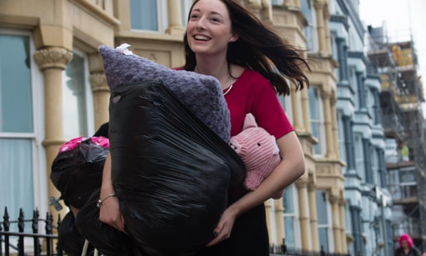A happy smiling first year ‘fresher’ woman student arrives at her halls of residence in Aberystwyth