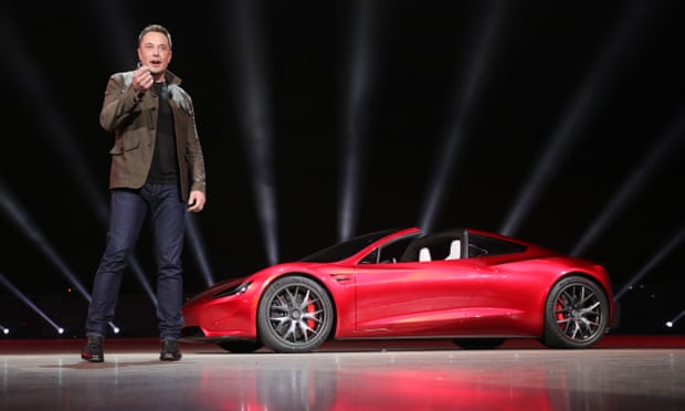 Elon musk unveils a red Tesla car