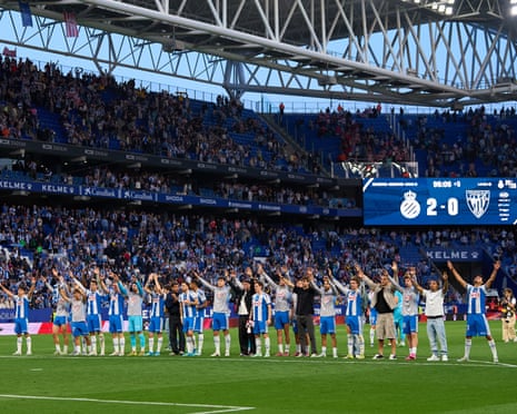 Espanyol players raise their arms to salute their fans after their victory following the La Liga match against Athletic Club