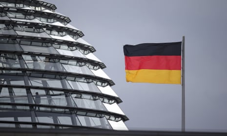 Germany flag next to the dome of the Reichstag building