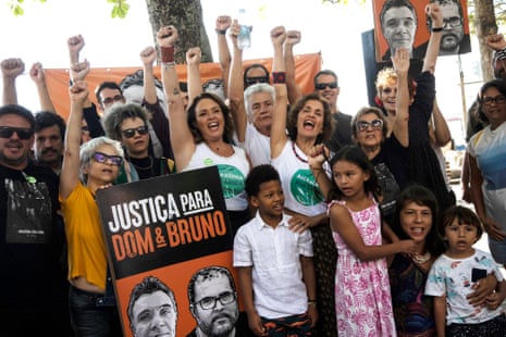 Relatives of British journalist Dom Phillips and activists hold a large poster with his image, left, and that of Indigenous activist Bruno Pereira, with the Portuguese message: "Justice for Dom and Bruno"