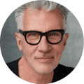 Michael Cunningham, a man in glasses smiling in portrait