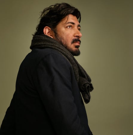 Oncologist Siddhartha Mukherjee, in black jacket and scarf, against green background, photographed in New York, October 2022