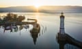 Lindau at Sunrise Bodensee Harbor Bavaria Germany<br>Sunrise over Bodensee Harbor Entrance of Lindau with the famous Lighthouse and Bavarian Lion Sculpture (from the year 1856). Sunrise, Aerial Drone point of View. Lindau, Bodensee, Bavaria, Germany.