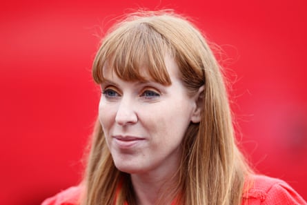 Close up photo of Angela Rayner stood before red background