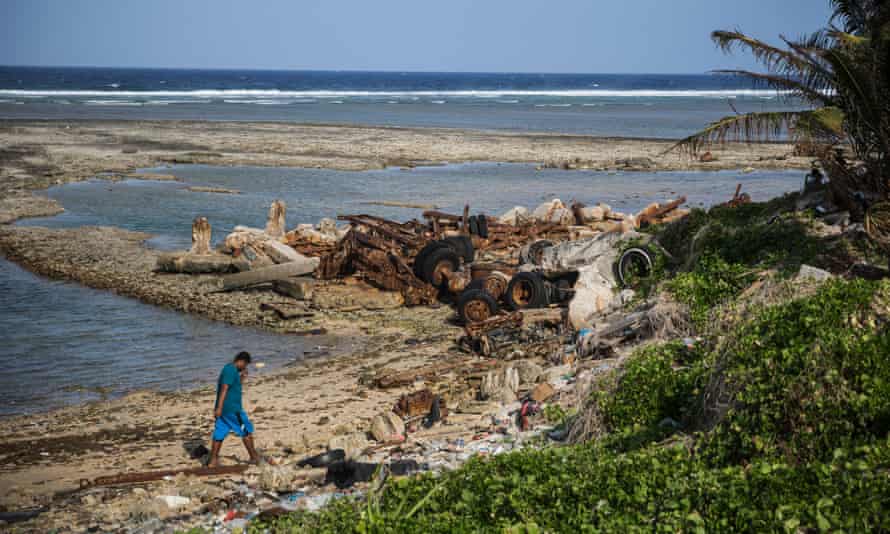 A man walks along the eroded coastline in Jenrok village – one of many places on the Marshall Islands affected by rising seas.
