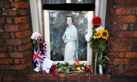 A picture of the Queen and floral tributes in a window in Windsor.